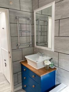 La salle de bains est pourvue d'un lavabo et d'un miroir. dans l'établissement Snowdon Cottage, à Dinorwic