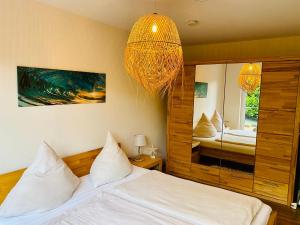 une chambre avec un lit et un lustre dans l'établissement FeWo SONNENDECK Familien-strandnah-Garten-Hunde-Sport-und Schwimmbadnah-HansaPark, à Sierksdorf 19 autres photos