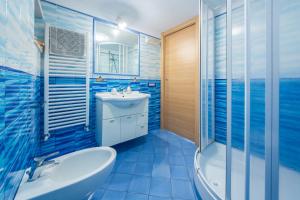 un bagno blu con vasca, lavandino e doccia di YourHome - Lorena Maria House Positano a Positano Altre 31 foto