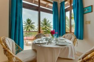 ein Esszimmer mit einem Tisch, Stühlen und einem Fenster in der Unterkunft Almond Beach Resort at Jaguar Reef in Hopkins