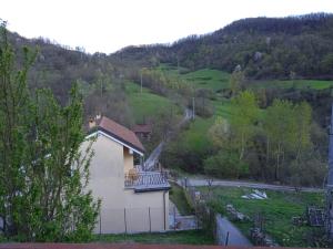 uma casa com uma varanda no lado de uma colina em Milky's House em Isola del Cantone