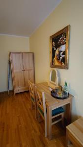 a dining room with a table and a painting on the wall at Villa Bali Pokoje ulica Strumykowa 6 59-850 ŚWIERADÓW ZDRÓJ in Świeradów-Zdrój