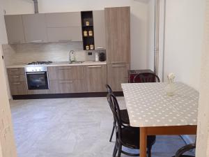 a kitchen with a table and a table and chairs at Milky's House in Isola del Cantone