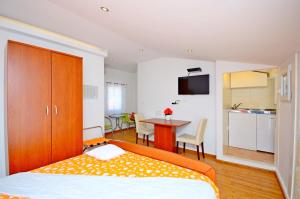 a bedroom with a bed and a table and a kitchen at Villa Capo in Split