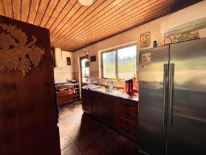 een keuken met een roestvrijstalen koelkast en een raam bij Casa Campestre in Molina
