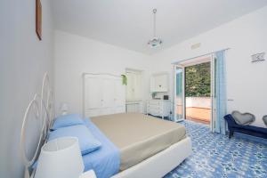 una camera da letto bianca con un letto e un balcone di YourHome - Lorena Maria House Positano a Positano