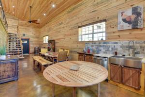 una cocina con paredes de madera y una mesa en una cabaña en Early Cabin with Deck about 20 Mi to Lake Brownwood! en Early