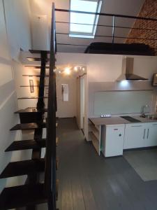 - un escalier dans une chambre avec une cuisine et un évier dans l'établissement Le Cosy, 