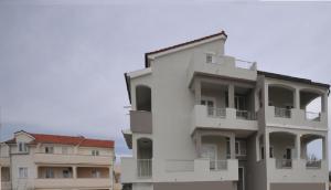 un edificio blanco con balcones en un lateral en Antodo Relax en Novalja