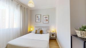 Habitación blanca con cama y ventana en Porvenir Diseño Moderno, en Jerez de la Frontera