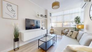 sala de estar con sofá y TV en Porvenir Diseño Moderno, en Jerez de la Frontera