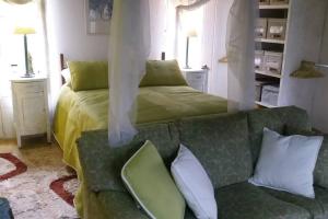ein Schlafzimmer mit einem grünen Bett und einem Sofa in der Unterkunft Suite Campestre Flamingo Paipa Boyaca in Paipa
