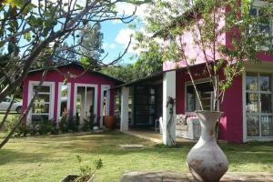 ein rosa Haus mit einer Vase davor in der Unterkunft Suite Campestre Flamingo Paipa Boyaca in Paipa