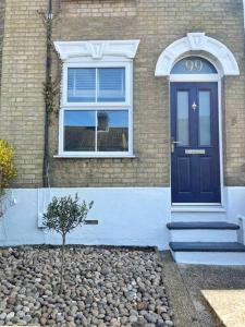 una casa con una porta blu e un albero davanti di Family Friendly House in Norwich with Parking a Norwich