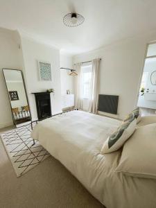 a white bedroom with a large bed and a fireplace at Family Friendly House in Norwich with Parking in Norwich