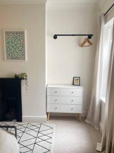 a bedroom with a white dresser and a window at Family Friendly House in Norwich with Parking in Norwich