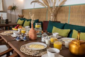 a wooden table topped with plates of food and drinks at Riad Agathe & Spa in Marrakesh