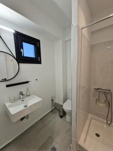 a white bathroom with a sink and a shower at plefsea in Afitos