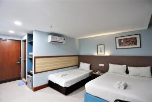 pokój hotelowy z dwoma łóżkami i telewizorem w obiekcie ORKID Hills at Pudu w Kuala Lumpur