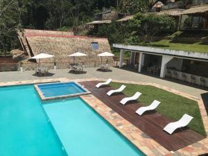 uma piscina com cadeiras e guarda-sóis ao lado de um edifício em Riosol Hotel Laguna Azul em Sauce