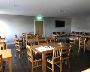 a room with tables and chairs and a flat screen tv at Dunshamrock @Sheep Island View in Ballintoy