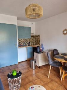 a living room with a table and a kitchen at studio cabine. Terrasse in Le Lavandou