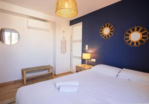 - une chambre avec un lit blanc et un mur bleu dans l'établissement Magnifique 3 pièces - Proximité Place des Lices avec parking, à Saint-Tropez