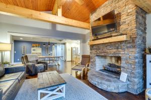 a living room with a large stone fireplace at Lakefront Butler Home with Hot Tub, Fire Pit and Dock in Butler