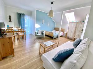 a living room with a couch and a dining room at Szary Domek Apartamenty Ustka in Ustka