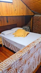 - un grand lit dans une chambre dotée de murs en bois dans l'établissement Recanto das Pipas - Hospedagem Diferenciada, à São Valentim do Sul