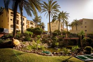 un giardino di fronte a due edifici con palme di Fantastic Sea View Apartament DOÑA LOLA a Mijas