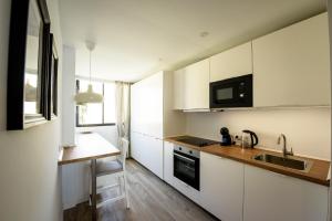 una piccola cucina con armadi bianchi e lavandino di Fantastic Sea View Apartament DOÑA LOLA a Mijas