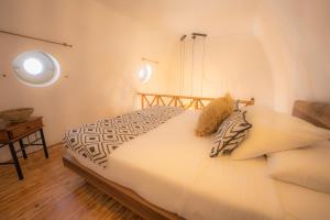 a white bed in a room with a window at Lovely House at Oia Village Center in Oia +45 photos