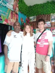 a woman and two men posing for a picture at Save's Homestay in Nadi