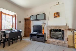 ein Wohnzimmer mit einem Kamin, einem Tisch und einem TV in der Unterkunft La casina nel paese a 20 minuti da Civita di Bagnoregio in Grotte Santo Stefano