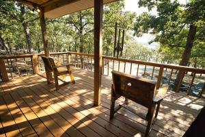 eine Veranda mit zwei Bänken auf einer Holzterrasse in der Unterkunft Bristow Blue - Lake front with Boat Ramp Access!! in Canadian