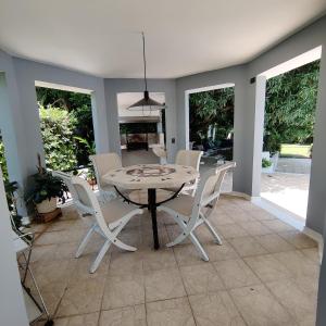 a dining room with a table and white chairs at Condominio El Peñon in Girardot