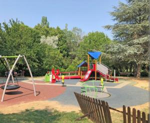 um parque com um parque infantil com escorrega e baloiços em BlancoHouse - Sul Parco em Riccione