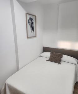 a white bed in a bedroom with a picture on the wall at Apartamentos en Alameda junto al Corte Inglés in Cartagena