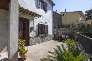 ein Haus mit einer Tür und einem Innenhof mit Pflanzen in der Unterkunft La casina nel paese a 20 minuti da Civita di Bagnoregio in Grotte Santo Stefano