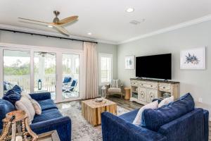 sala de estar con 2 sofás azules y TV de pantalla plana en Sandcastle by the Sea, en Pensacola