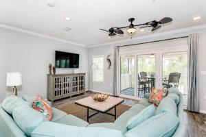 een woonkamer met een blauwe bank en een tafel bij Beach Happy in Pensacola
