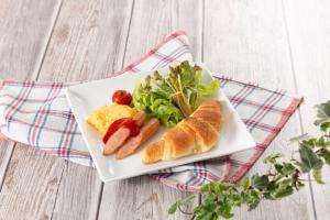 un piatto di cibo con hot dog e insalata di ホテルDEN a Tokyo 1 altra foto