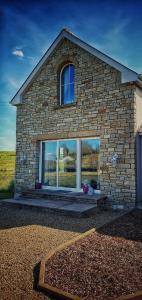 a brick house with a large window on it at Tully View House in Donegal