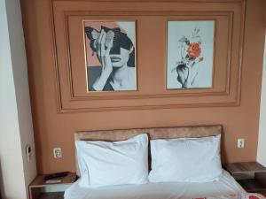 a bedroom with two pictures on the wall above a bed at Petreski Apartments 1 in Ohrid