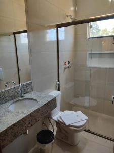 a bathroom with a toilet and a sink and a shower at Hotel Vale Do Ivinhema in Bataiporã