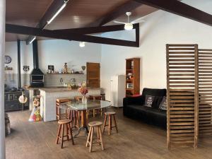 a kitchen and a living room with a table and chairs at Casa Chalé na Barra da Tijuca Com Piscina Próximo a Praia in Rio de Janeiro