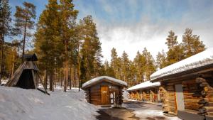 una cabaña de madera en la nieve junto a un bosque en Ski-in-out FreeRider, en Pyhätunturi