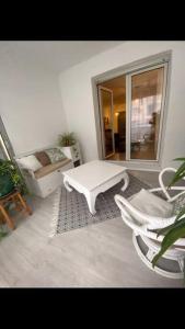a living room with a white table and chairs at Superbe appartement avec piscine l'été in Nice