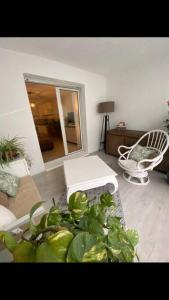 a living room with a couch and a chair and a plant at Superbe appartement avec piscine l'été in Nice